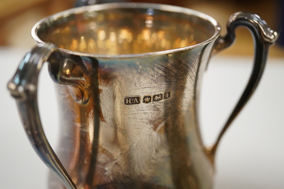 Two George V silver loving cups, one by Atkin Brothers, Sheffield, 1926, height 89mm and a set of four silver Hanoverian pattern dessert forks, Birmingham, 1930, 16.4oz.